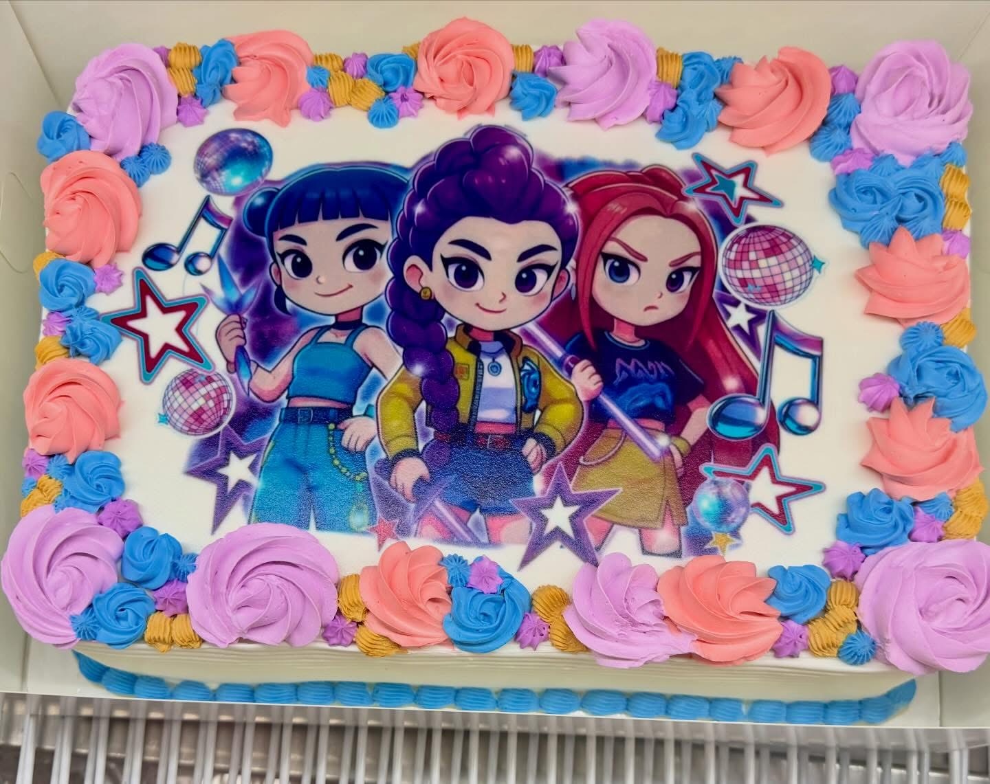 Character-print custom sheet cake decorated with pastel rosettes