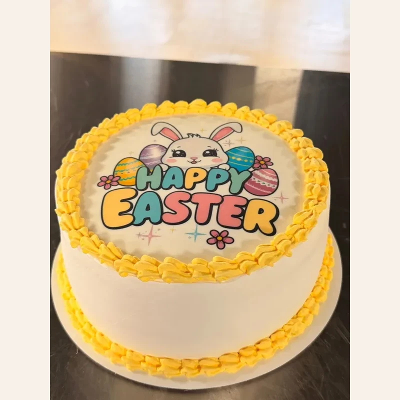 Easter themed round cake decorated with a rabbit and yellow frosting border