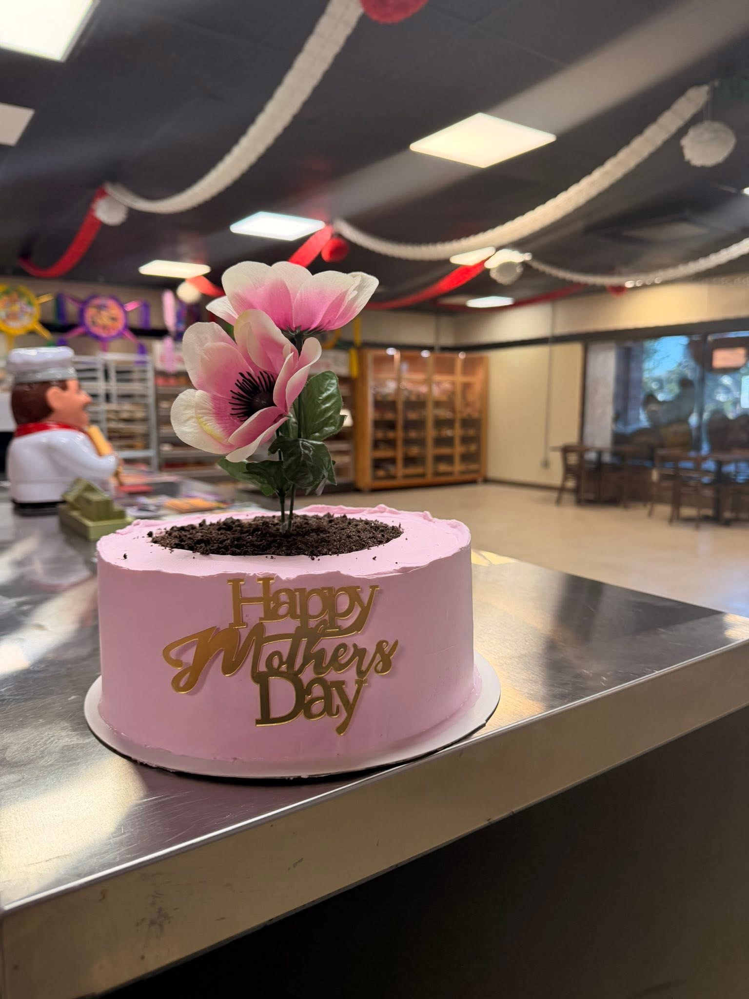 Pink custom Mother's Day cake decorated with a large flower topper