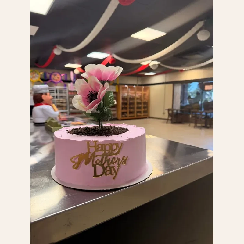 Pink custom Mother's Day cake decorated with a large flower topper