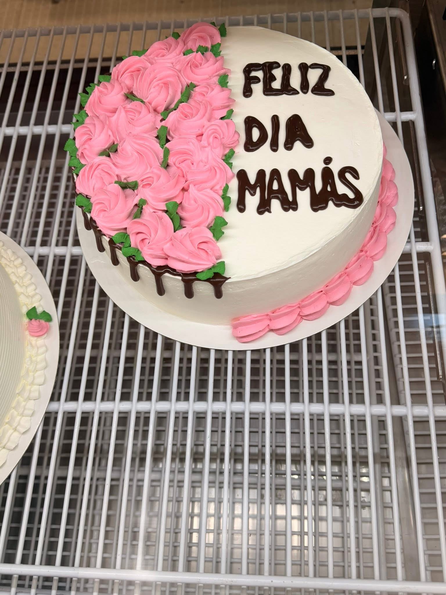 Feliz Día Mamás custom cake decorated with pink frosting roses