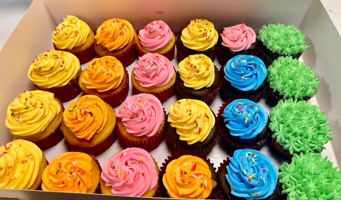 Box of assorted colorful iced cupcakes