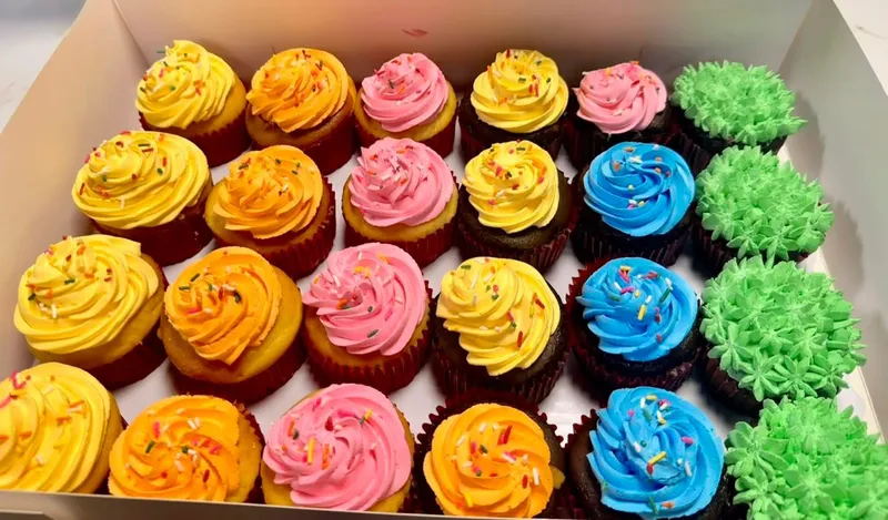 Box of assorted colorful iced cupcakes