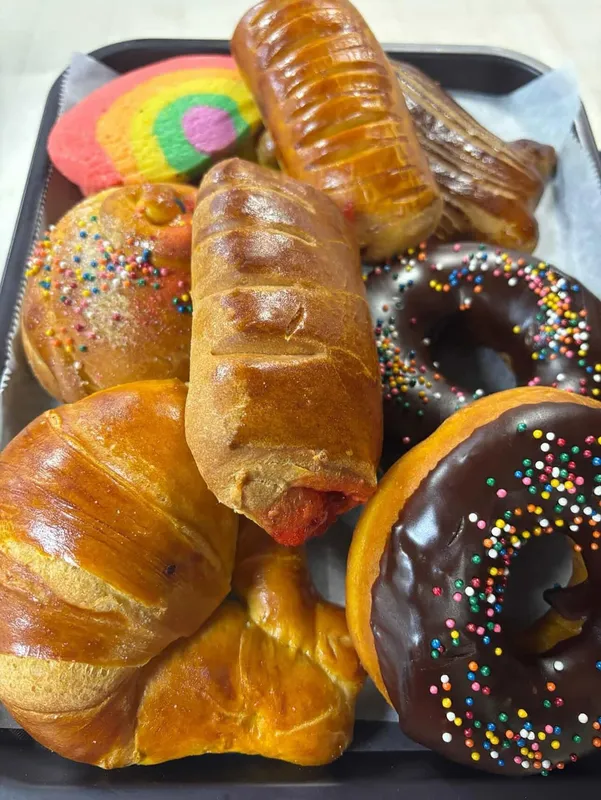 Assorted tray of fresh Mexican sweet breads including cuernos and donuts