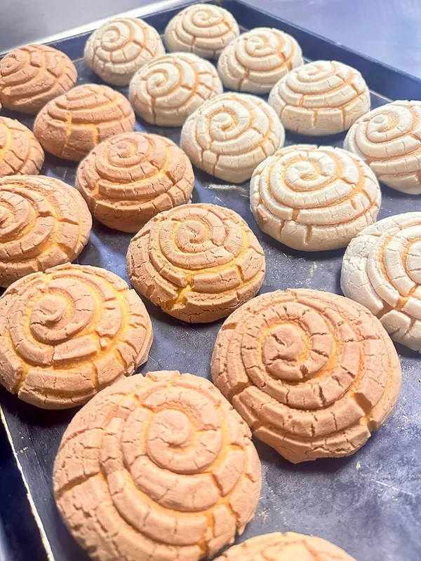 Tray of fresh pink, white, and yellow conchas