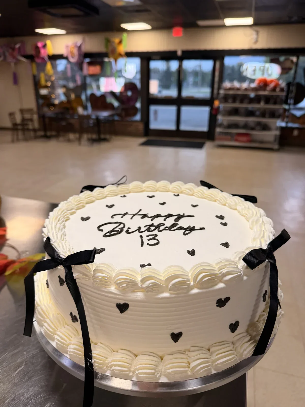 Vintage coquette 13th birthday cake with black ribbon bows and black piped hearts